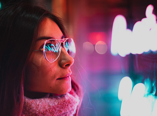 mujer con gafas frente a pantalla led